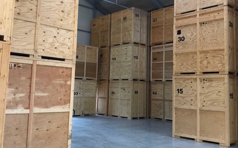 Gestapelte, nummerierte Lagerboxen aus Holz in einer Möbel-Lagerhalle